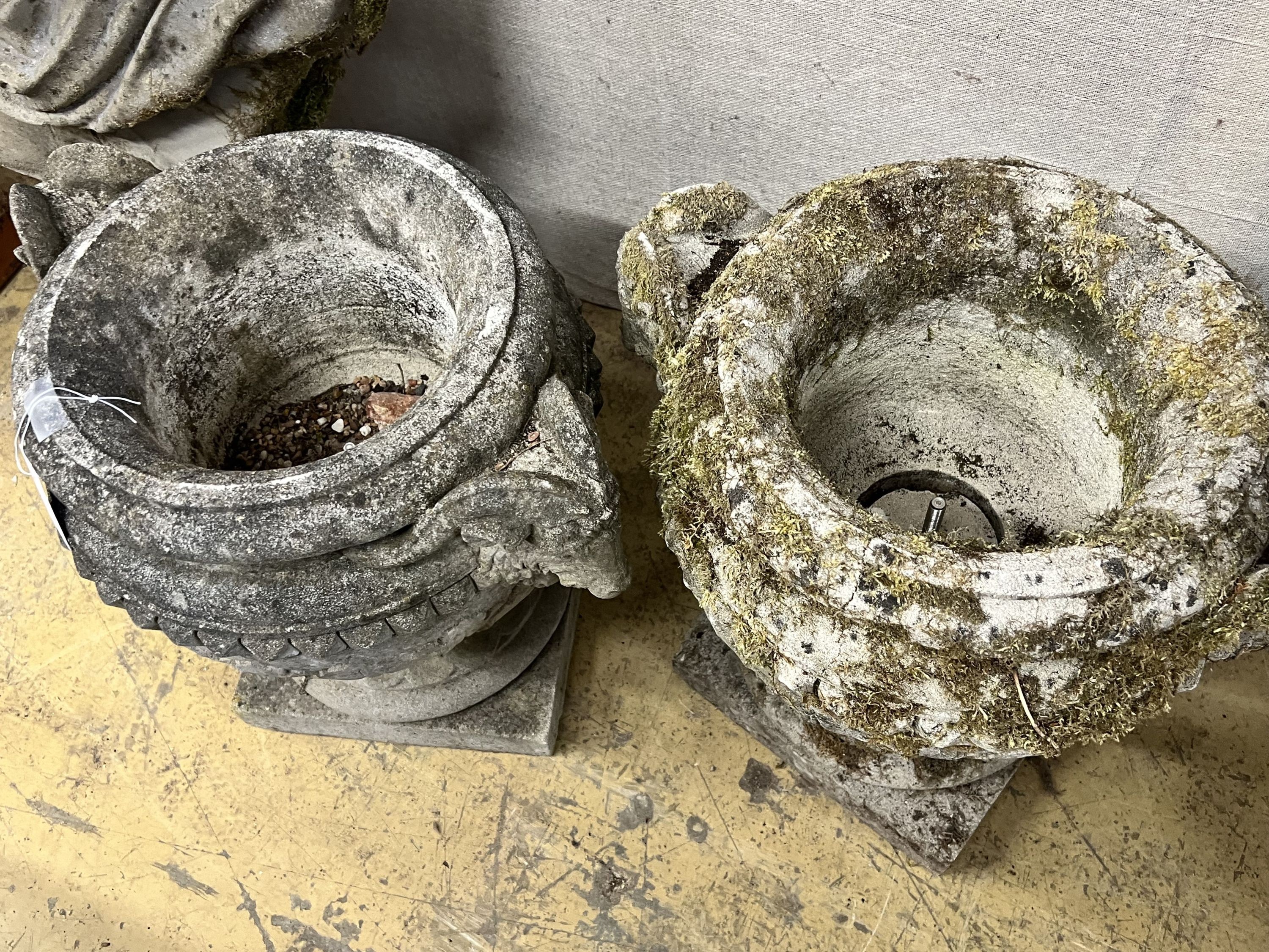 A pair of reconstituted stone circular rams head garden urns, width 50m height 46cm